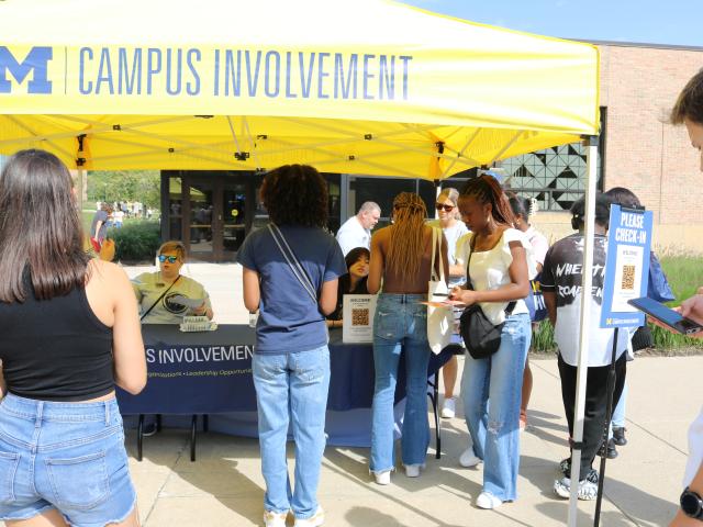 Students approach a Campus Involvement tent