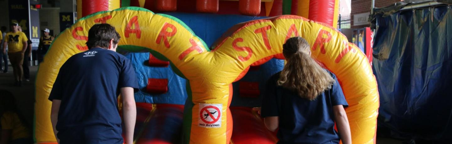 Two students ready to enter an inflatable obstacle course